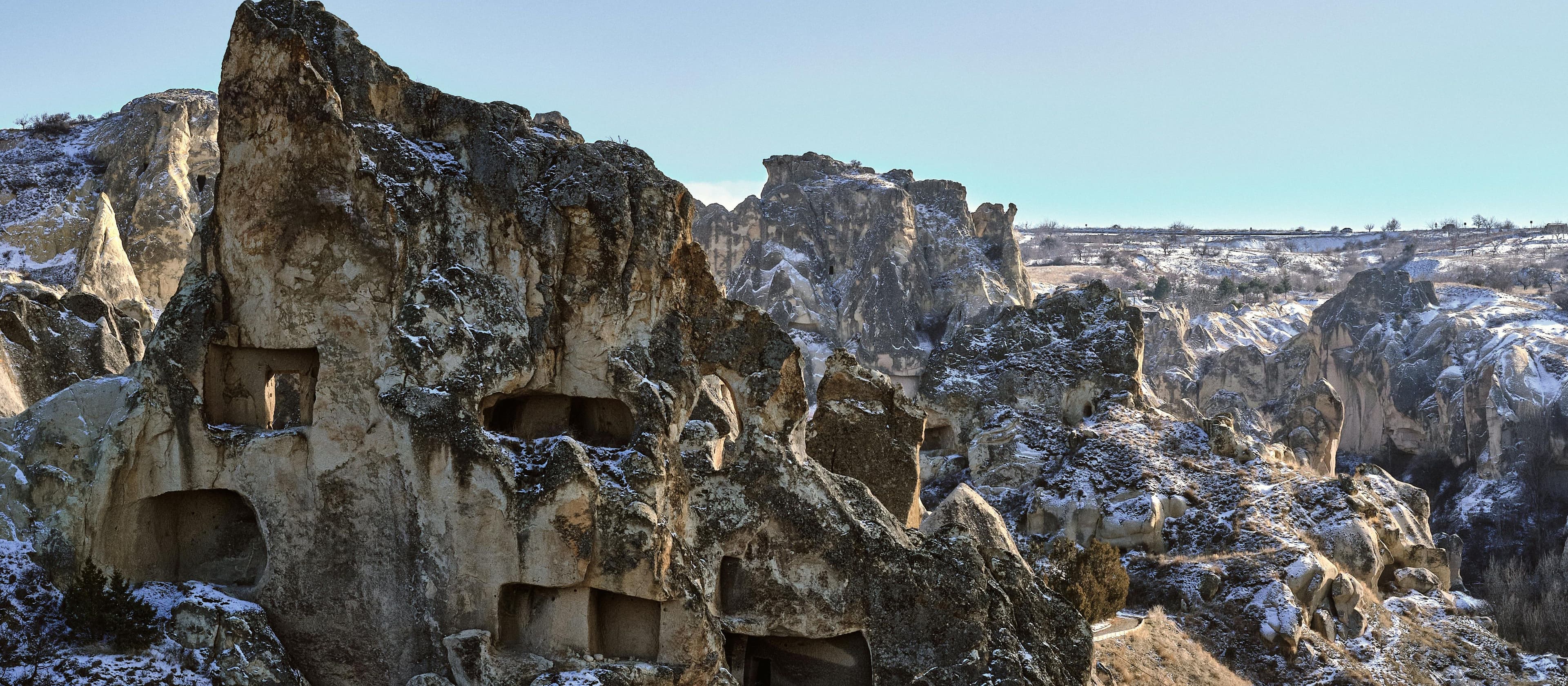 Ancient cave monastery of Vardzia carved into dramatic rocky cliffs with snow-dusted landscape in Javakheti plateau