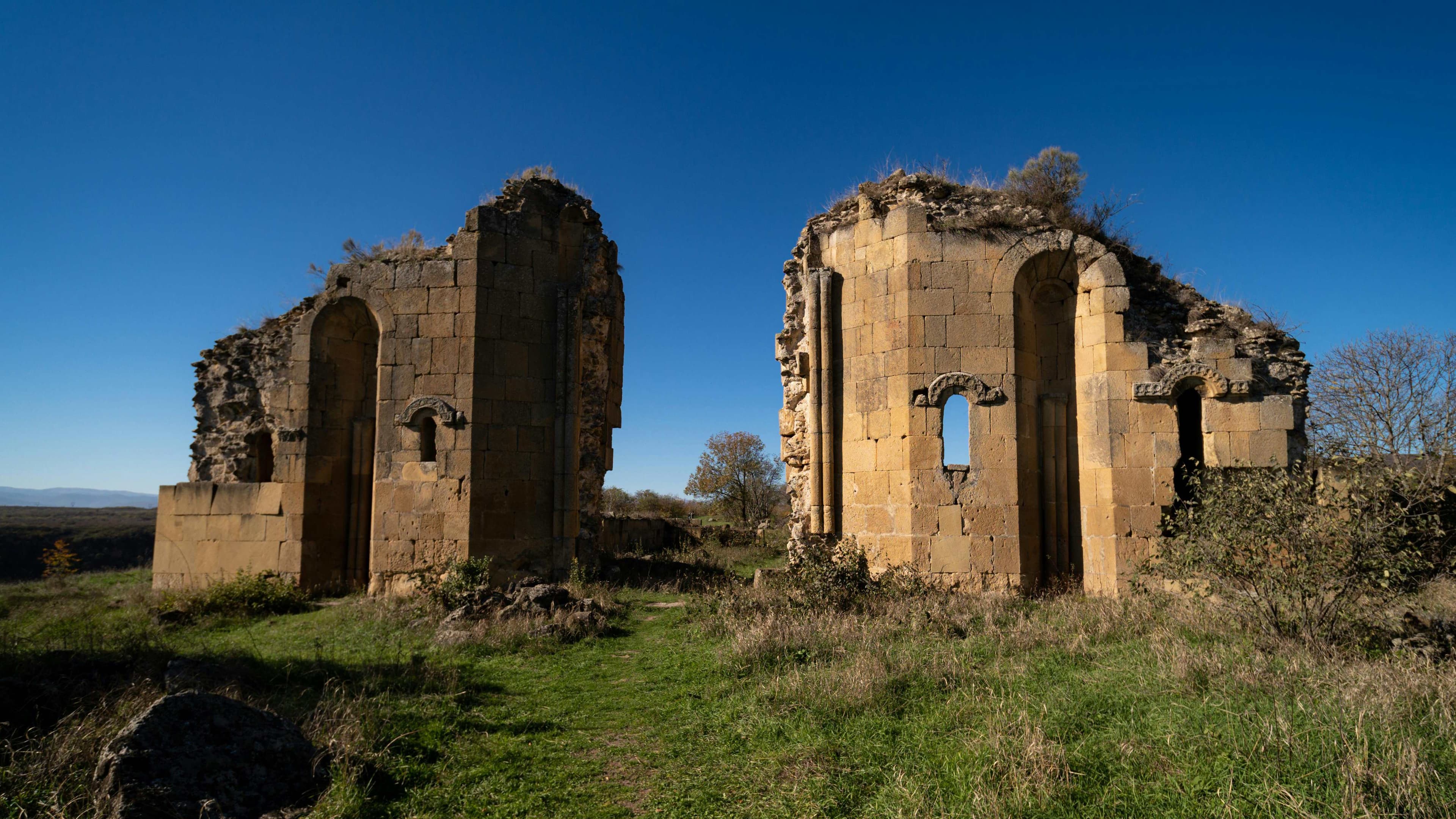 Ancient stone ruins of Samshvilde medieval fortress with impressive arched openings and weathered walls against clear blue sky
