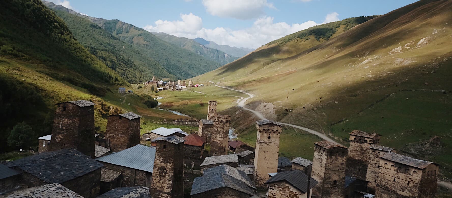 Svanetian Towers in Ushguli - UNESCO World Heritage Architecture Medieval Svanetian defensive towers in UNESCO-protected Ushguli village with snow-capped Caucasus peaks in background