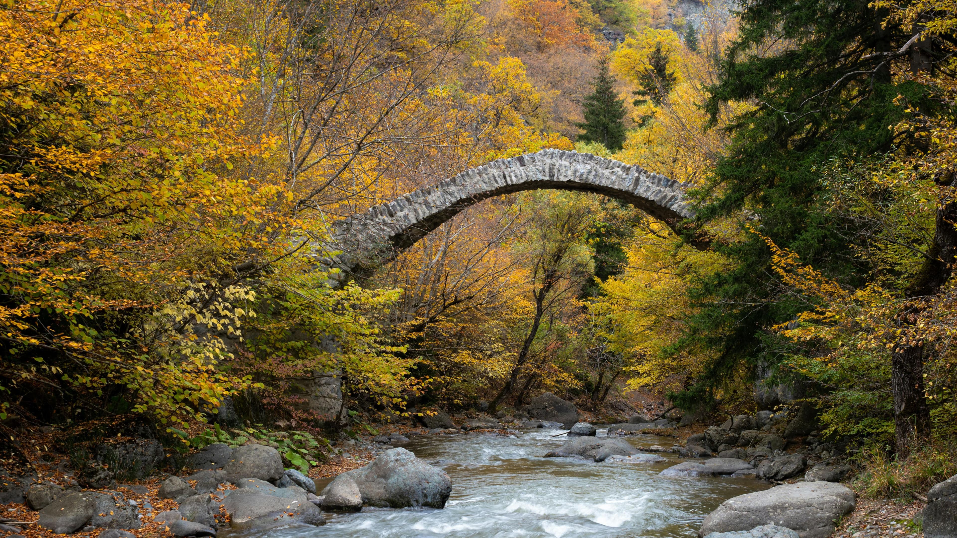 Georgian autumn landscape with stone arch bridge
